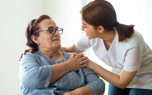 Nurse embracing an elderly woman